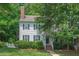 Charming two-story home with white siding, dark shutters, brick chimney and lush landscaping at 1701 Berwickshire Cir, Raleigh, NC 27615