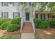 Charming two-story home with white siding, blue shutters, landscaped yard, and inviting brick steps at 1701 Berwickshire Cir, Raleigh, NC 27615