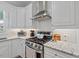 Stainless steel stove and hood with white subway tile backsplash at 1701 Berwickshire Cir, Raleigh, NC 27615