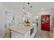 Bright kitchen featuring a large island with granite countertop, pendant lighting, and a red display cabinet at 1701 Berwickshire Cir, Raleigh, NC 27615