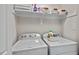 A well-organized laundry room with a modern washer and dryer and storage shelves at 1701 Berwickshire Cir, Raleigh, NC 27615