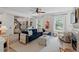 Bright living room featuring a plush blue sofa, white accents, and large windows with natural light at 1701 Berwickshire Cir, Raleigh, NC 27615