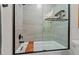 Close-up of a tiled shower with matte black fixtures and a built-in wooden bench at 1701 Berwickshire Cir, Raleigh, NC 27615