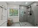 Modern bathroom with a glass-enclosed shower featuring gray tiling and black fixtures and a window at 1701 Berwickshire Cir, Raleigh, NC 27615