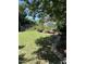 Lush backyard with a well-maintained lawn, vegetable garden, and mature trees at 1831 Devonridge Dr, Fuquay Varina, NC 27526