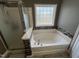 Bathroom featuring a soaking tub with modern mosaic tile surround and glass-enclosed shower at 1831 Devonridge Dr, Fuquay Varina, NC 27526