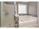 Bathroom features a tub with decorative tiling and a shower at 1831 Devonridge Dr, Fuquay Varina, NC 27526