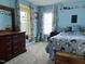 Bright bedroom with blue walls, patterned curtains, and a comfortable-looking bed and furniture at 1831 Devonridge Dr, Fuquay Varina, NC 27526