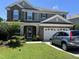 Charming two-story home with stone accents, attached garage, well-kept lawn, and car parked in the driveway at 1831 Devonridge Dr, Fuquay Varina, NC 27526