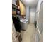 Well-lit laundry room with wooden cabinets, a washer, overhead shelves, and tan-colored tile flooring at 1831 Devonridge Dr, Fuquay Varina, NC 27526