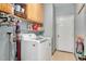 Well-equipped laundry room with washer, dryer, storage cabinets, and ample shelving at 1831 Devonridge Dr, Fuquay Varina, NC 27526