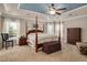 Main bedroom features a four post bed, sitting chair, and tray ceiling with fan at 1831 Devonridge Dr, Fuquay Varina, NC 27526