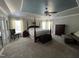 Spacious main bedroom featuring a tray ceiling, large windows, neutral carpet and ensuite bathroom at 1831 Devonridge Dr, Fuquay Varina, NC 27526