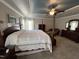 Bright main bedroom with large bed, sitting area, dresser, carpet flooring and ceiling fan at 1831 Devonridge Dr, Fuquay Varina, NC 27526
