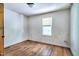 Cozy bedroom features wood floors, a single window, and a door at 1907 Bivins St, Durham, NC 27707