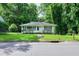 Charming one-story home featuring a cozy front yard and light-colored exterior with green shutters at 1907 Bivins St, Durham, NC 27707