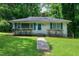 Inviting home with a well-maintained lawn, complemented by charming green shutters and fresh landscaping at 1907 Bivins St, Durham, NC 27707