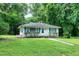 Charming single-story home with green shutters and a well-manicured front lawn surrounded by mature trees at 1907 Bivins St, Durham, NC 27707