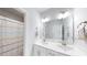 Well-lit bathroom featuring a double vanity, large mirror, and colorful shower curtain at 199 High Woods Rdg, Chapel Hill, NC 27517
