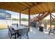 Relaxing covered patio area with a dining table and a fire pit sitting area overlooking a grassy lawn at 199 High Woods Rdg, Chapel Hill, NC 27517