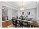 Spacious dining room featuring a large wooden table and chairs, modern lighting, and a view of the staircase at 199 High Woods Rdg, Chapel Hill, NC 27517
