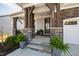 Inviting front porch with stone accents, wooden columns, and a view of the entryway and front lawn at 199 High Woods Rdg, Chapel Hill, NC 27517