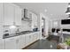Well-lit kitchen with white cabinetry, gray countertops and backsplash, stainless steel appliances and views of the living room at 199 High Woods Rdg, Chapel Hill, NC 27517