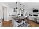 Stylish kitchen with a large central island, white cabinetry, and modern pendant lighting open to the living room at 199 High Woods Rdg, Chapel Hill, NC 27517