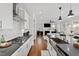 Modern kitchen with white cabinets, stainless steel appliances, gray countertops and backsplash, and hardwood flooring at 199 High Woods Rdg, Chapel Hill, NC 27517