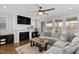Comfortable living room featuring hardwood floors, a fireplace, large windows with natural light, and a gray sectional sofa at 199 High Woods Rdg, Chapel Hill, NC 27517