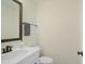 Half bath featuring a vanity with a white top, framed mirror, and bronze fixtures at 2055 Eva Pearl Dr, Apex, NC 27502