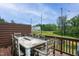 Outdoor deck with a wooden table and scenic views of trees and other homes at 2055 Eva Pearl Dr, Apex, NC 27502