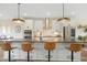 Kitchen features an island with barstool seating, pendant lighting and stainless steel appliances at 2055 Eva Pearl Dr, Apex, NC 27502
