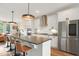 Modern kitchen boasts a large island with seating, stainless steel appliances and white cabinets at 2055 Eva Pearl Dr, Apex, NC 27502