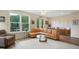 Elegant living room with an L-shaped sofa, lots of art and photos, and bright natural light at 2055 Eva Pearl Dr, Apex, NC 27502