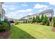 Spacious backyard with manicured lawn, privacy fence, mature trees and plantings in a desirable community at 212 Golf Vista Trl, Holly Springs, NC 27540