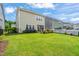 Expansive backyard featuring lush green grass, a black fence, and manicured landscaping and patio at 212 Golf Vista Trl, Holly Springs, NC 27540
