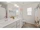 Bright bathroom with a double vanity, a window, and a tile floor at 212 Golf Vista Trl, Holly Springs, NC 27540