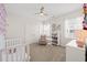 Bright bedroom with a crib, a comfortable chair, and neutral decor at 212 Golf Vista Trl, Holly Springs, NC 27540