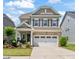 Charming two-story home with stone accents, a well-manicured lawn, and a two car garage at 212 Golf Vista Trl, Holly Springs, NC 27540