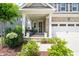 Inviting front porch with elegant columns, landscaping, and tasteful outdoor furniture at 212 Golf Vista Trl, Holly Springs, NC 27540