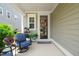 Cozy front porch featuring comfortable seating, potted plants, and a welcoming entrance at 212 Golf Vista Trl, Holly Springs, NC 27540