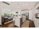 A modern kitchen with stainless steel appliances, a spacious island, and easy access to the living room at 212 Golf Vista Trl, Holly Springs, NC 27540