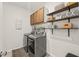 Well-organized laundry room with modern appliances, overhead cabinets, and decorative shelving at 212 Golf Vista Trl, Holly Springs, NC 27540