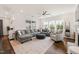 Comfortable living room with large windows, gray sectional sofa, and a cozy armchair at 212 Golf Vista Trl, Holly Springs, NC 27540