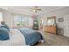Bright primary bedroom with a large window, dresser, and ensuite bathroom at 212 Golf Vista Trl, Holly Springs, NC 27540