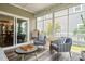 Cozy screened porch with stylish furniture and view to the backyard and patio at 212 Golf Vista Trl, Holly Springs, NC 27540
