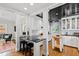 Bright kitchen with black ceilings and white cabinetry, featuring an island with seating at 2147 Wake Dr, Raleigh, NC 27608