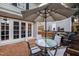 Relaxing brick patio area with outdoor seating, an umbrella, and mature landscaping at 2147 Wake Dr, Raleigh, NC 27608