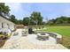 A backyard patio features a built-in firepit, seating, and grilling area for entertaining at 2320 Marks Creek Rd, Knightdale, NC 27545